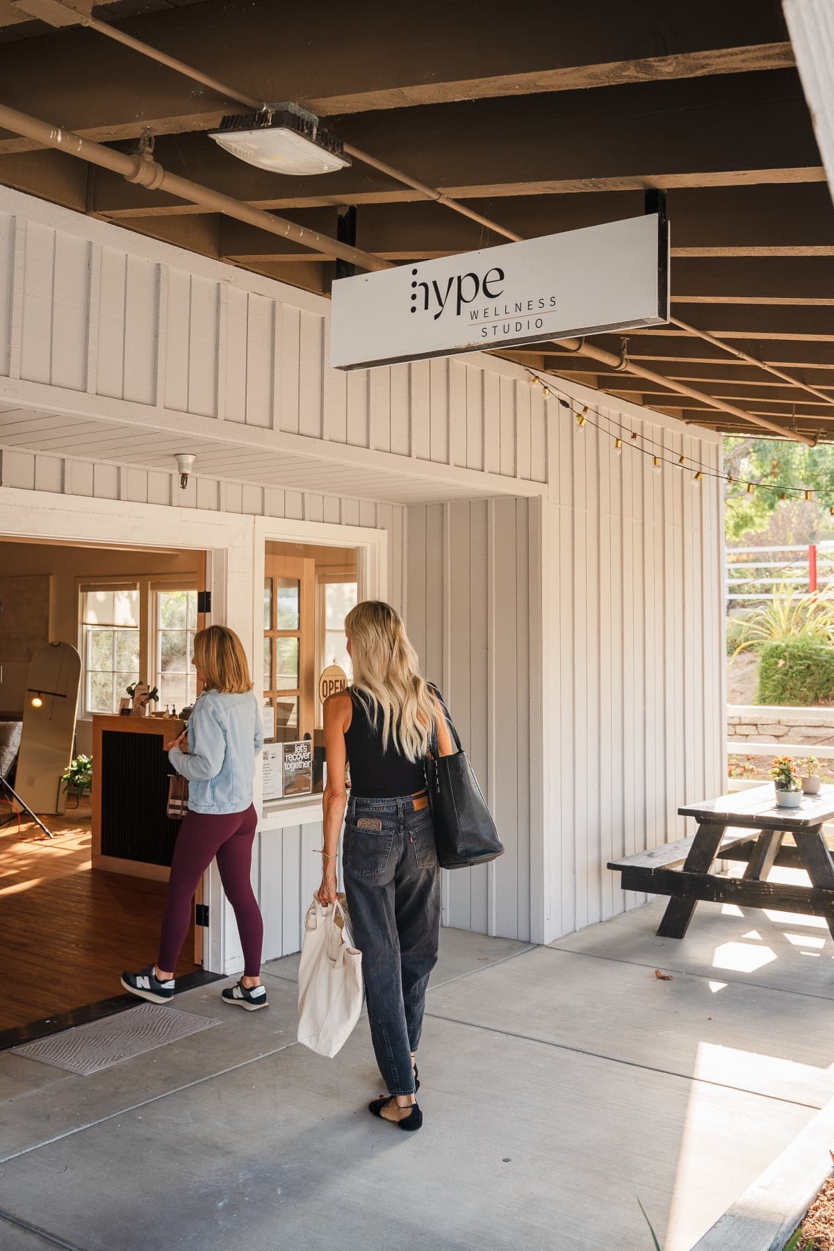 Two members walking into the Hype Wellness Studio storefront in San Juan Capistrano