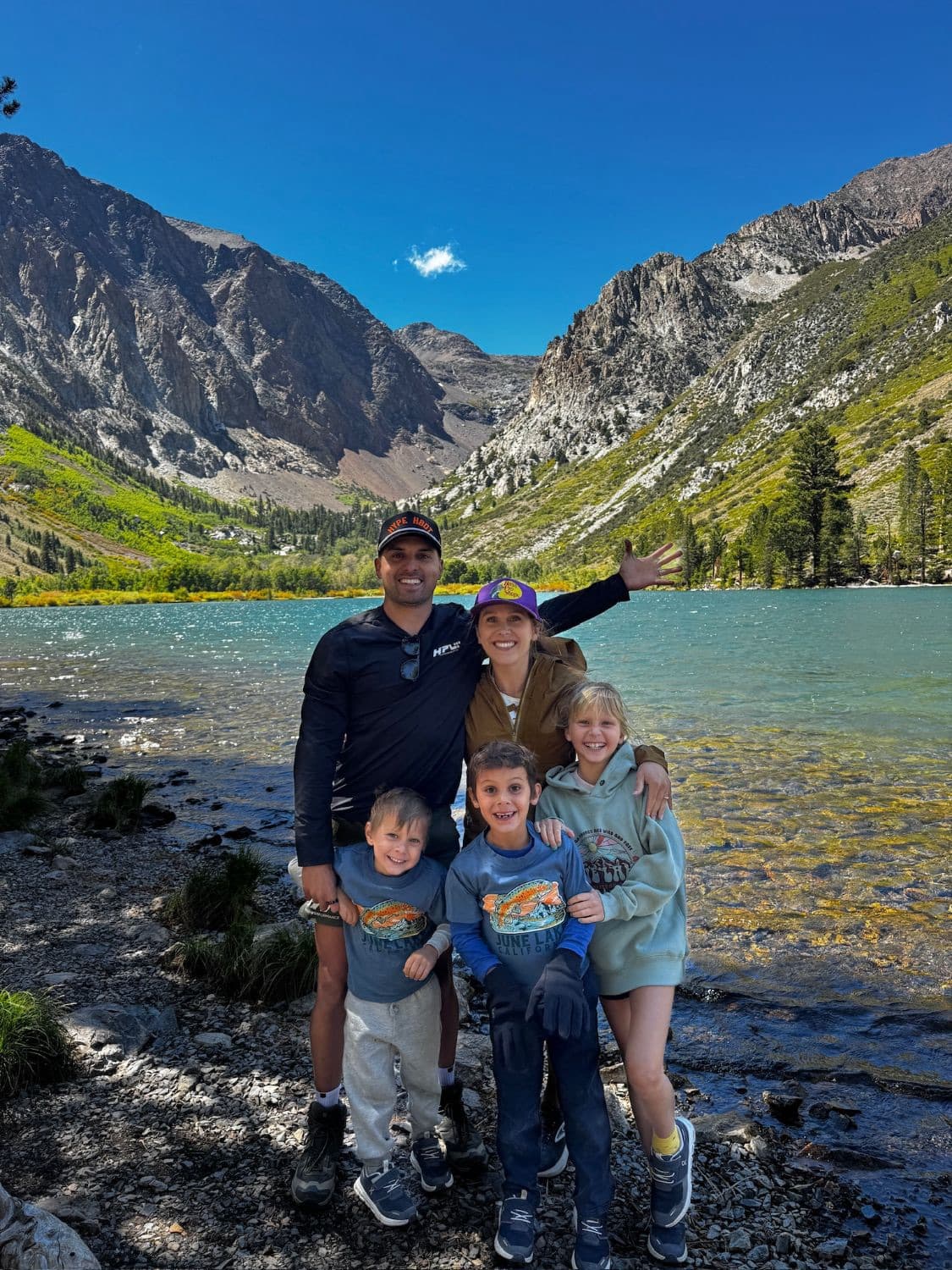 The Guzman family — Daniel, Lauren, Ivy, Theo, and Jude — at a mountain lake
