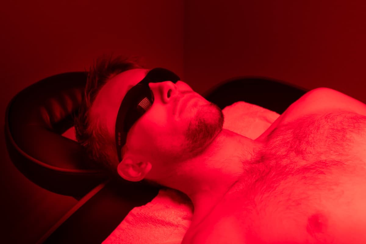 A member relaxing under red light panels